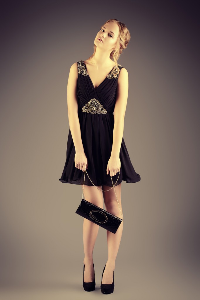 Full length portrait of a pretty young woman in little black dress. Beauty, fashion. Studio shot.